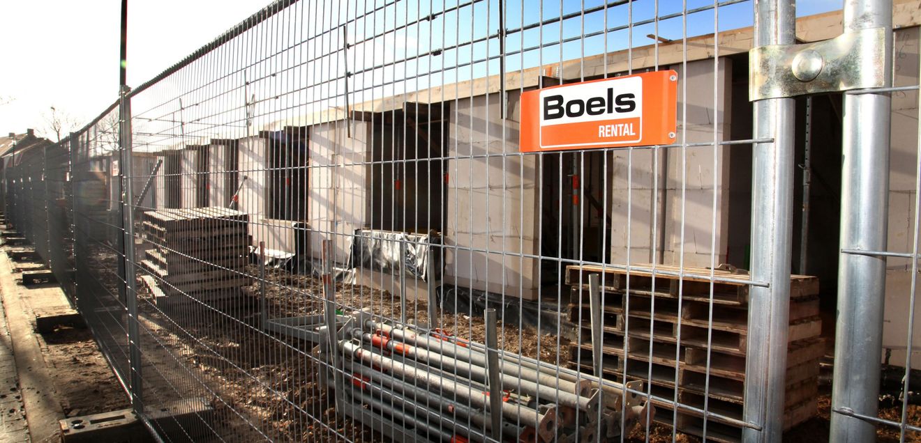 Ein Bauzaun von Boels Rental, der eine Baustelle sichert.