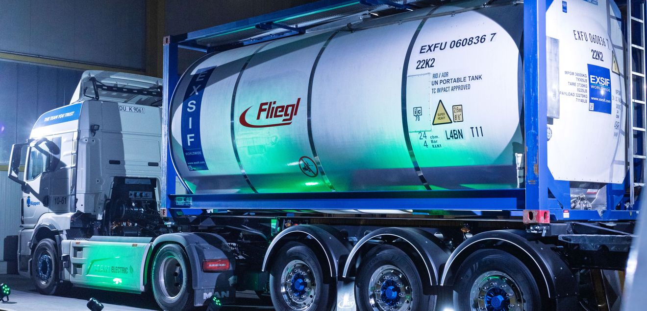 Fliegl Ein Sattelzug von Fliegel vor einer Werkshalle