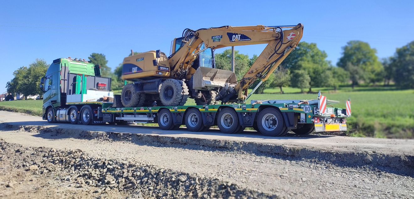 Messe-Triple für Goldhofer im Jahr 2024 ein Goldhofer Anhänger, auf dem ein Caterpillar-Bagger steht, samt Zugmaschine