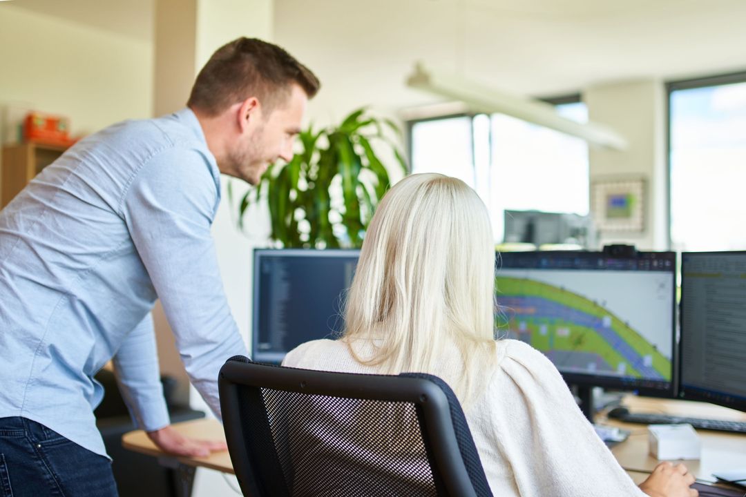 Materialfluss Ein männlicher und ein weiblicher Mitarbeiter prüfen die Logistik auf einem Computerbildschirm