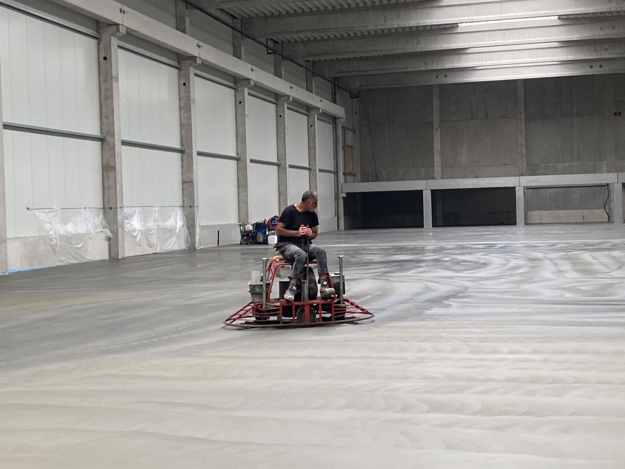 NEODUR HE 3 green lässt genauso einfach verarbeiten wie herkömmliche Einstreuprodukte. Nach dem Einstreuen wird das aufgebrachte Material zunächst eingerieben und anschließend geglättet, in diesem Fall mit einer Doppelglättmaschine.