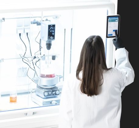 Labormitarbeiterin an der Bedieneinheit des Laborabzugs