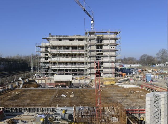 Baustelle eines Mehrparteienhauses, auf der Baumaschinen und Geräte stehen