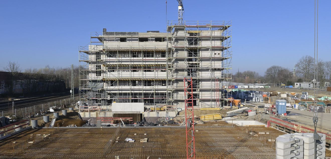 Wohngebäude Baustelle eines Mehrparteienhauses, auf der Baumaschinen und Geräte stehen