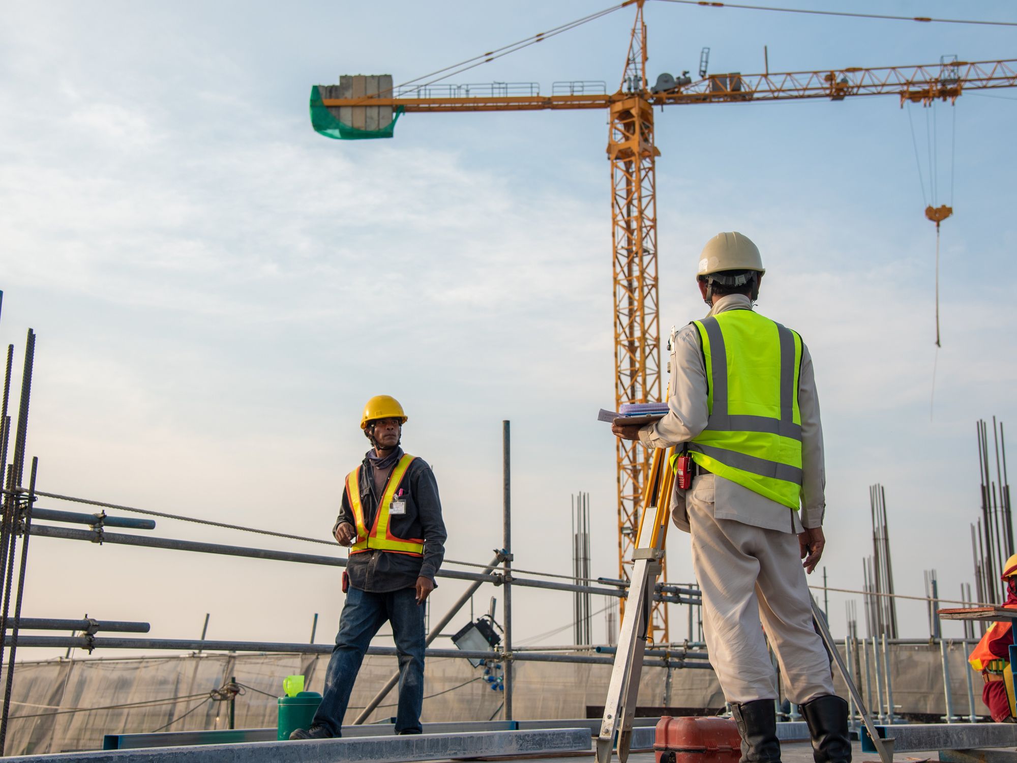 Rimatem und Riffel Bau & Fertigteile Bauarbeiter auf einer Baustelle vor Kranen