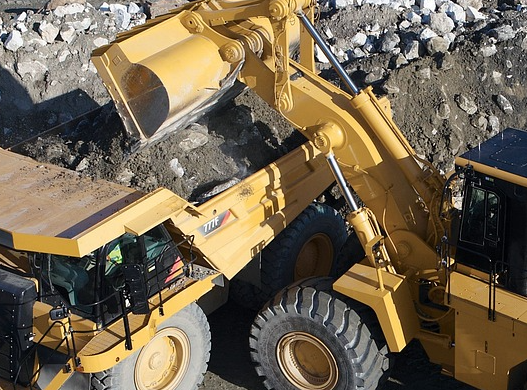 Nutzfahrzeuge im Rampenlicht: Innovative Lösungen für die Baustelle der Zukunft Ein Radlader belädt einen Dumper oder Muldenkipper mit Material