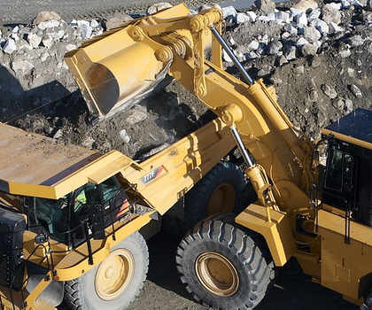 Ein Radlader belädt einen Dumper oder Muldenkipper mit Material