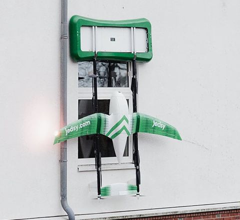 Asklepios Kliniken starten Flugtransport: Drohne transportiert Laborproben Drohne hängt vor dem Fenster an spezieller Halterung