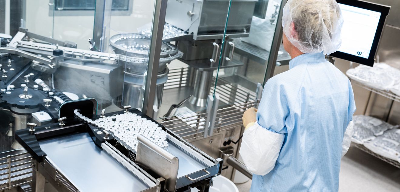 Mitarbeiterin im Labor Eine Arbeiterin steht an einer Abfüll- und Verschließanlage für pharmazeutische Produkte bei Takeda Pharmaceutical.