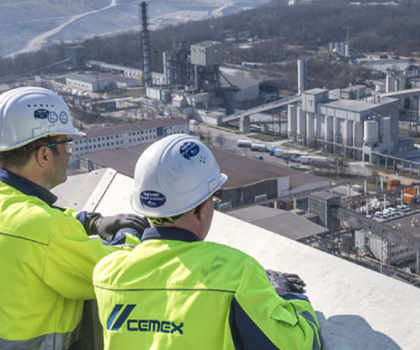 Cemex - Transparenz und Nachhaltigkeit Zwei Arbeiter blicken auf eine Anlage von Cemex zur Baustoffherstellung