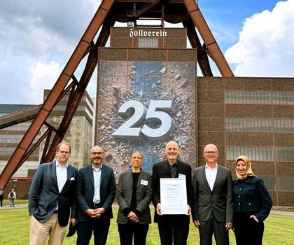 Sechs Personen (Präsidium und Geschäftsführung des VUP) stehen vor dem Förderturm der Zeche Zollverein in Essen