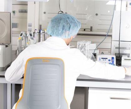 Arbeitsschutz im Labor: Warum Ergonomie ein wichtiger Bestandteil der Laborsicherheit ist Labormitarbeiter an einem Labortisch auf einem ergonomischen Laborstuhl der Marke Bimos