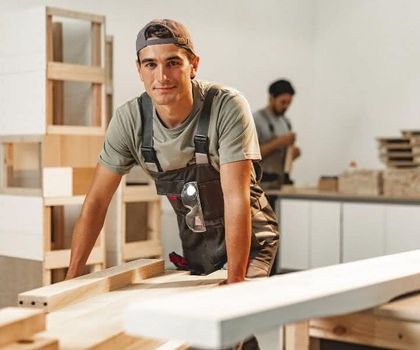 Ein junger männlicher Handwerker blickt freundlich in die Kamera