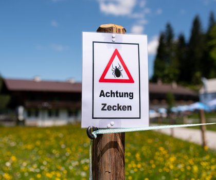 Zecken übertragen Krankheiten Ein Schild warnt an einem Wanderweg vor Zecken.