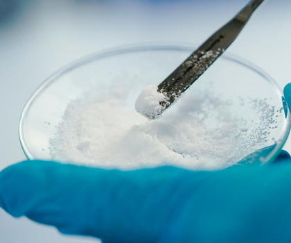 Eine Mitarbeiterin hält in einem Labor der Vulcan Energie eine Glasschale mit Lithiumchlorid in den Händen.