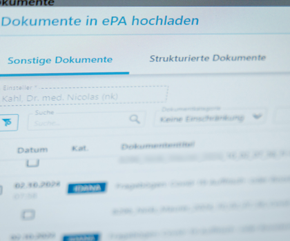 ePA für alle - Elektronische Patientenakte startet bundesweit Ein Hausarzt lädt in seiner Praxis Dokumente in eine elektronische Patientenakte "ePA".