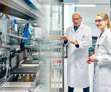 Graduiertenkolleg der Universitäten Jena und Bayreuth Prof. Dr. Ulrich S. Schubert und Dr. Natalie Göppert von der Universität Jena vor einem Syntheseroboter zur automatischen Durchführung von Copolymerisationen.