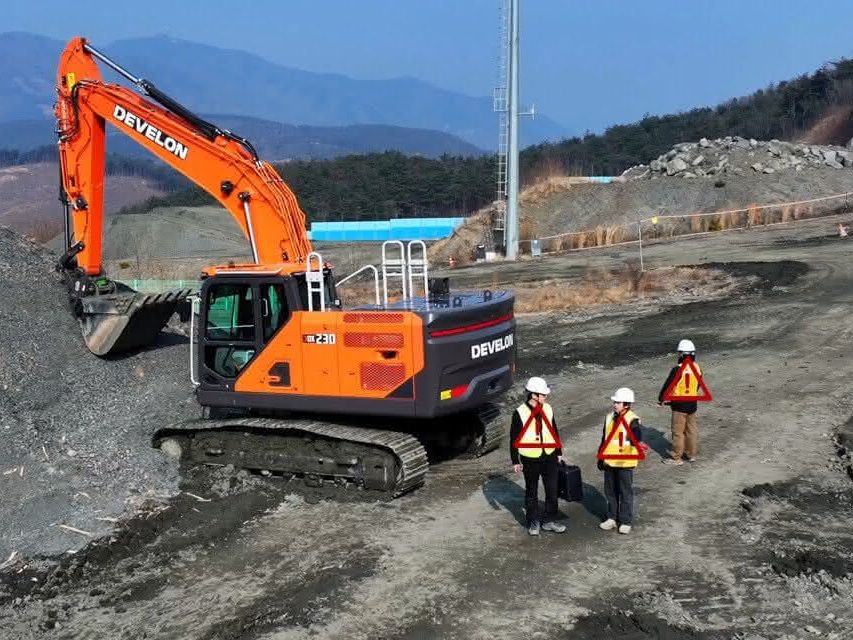 Develon Bagger Ein Develon Bagger lädt auf einer Deponie Material ein
