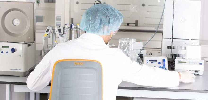 Arbeitsschutz im Labor: Warum Ergonomie ein wichtiger Bestandteil der Laborsicherheit ist Labormitarbeiter an einem Labortisch auf einem ergonomischen Laborstuhl der Marke Bimos