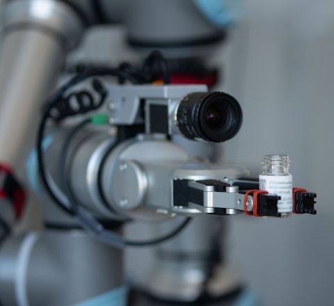 Handling eines Probenbehälters mit Roboterarm