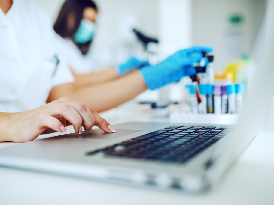 Forschung zu Pilzinfektionen: Zucker-Fingerabdrücke als Test nutzen Probenröhrchen im Labor und Labormitarbeitende mit Laptop