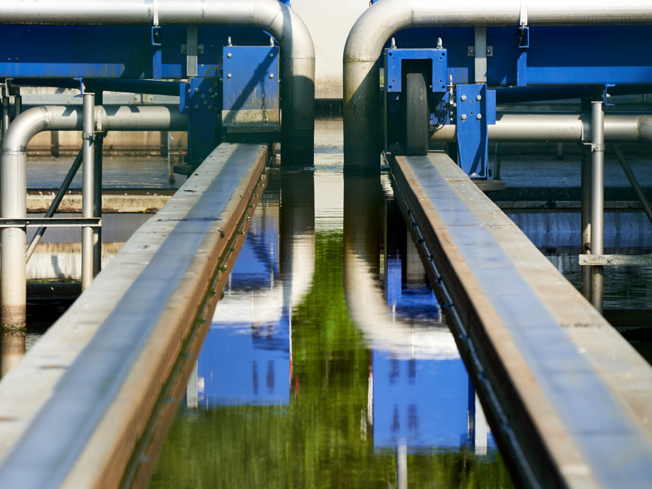 Abwassermonitoring zur Überwachung von Viren in Deutschland Detail einer Kläranlage in Deutschland: Blaue Stahlkonstruktion mit Rohren und Geländern. Filtert verschmutztes Wasser aus Gewässern.