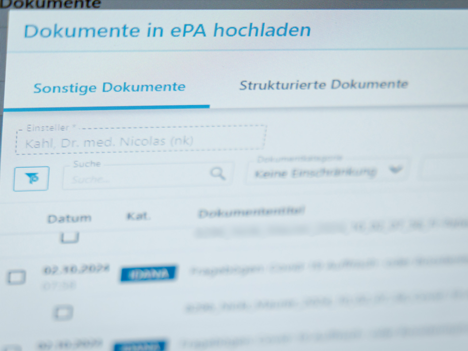 ePA für alle - Elektronische Patientenakte startet bundesweit Ein Hausarzt lädt in seiner Praxis Dokumente in eine elektronische Patientenakte "ePA".