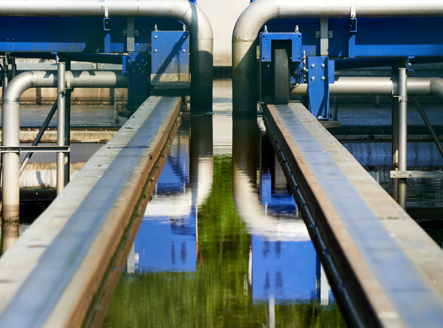 Abwassermonitoring zur Überwachung von Viren in Deutschland Detail einer Kläranlage in Deutschland: Blaue Stahlkonstruktion mit Rohren und Geländern. Filtert verschmutztes Wasser aus Gewässern.