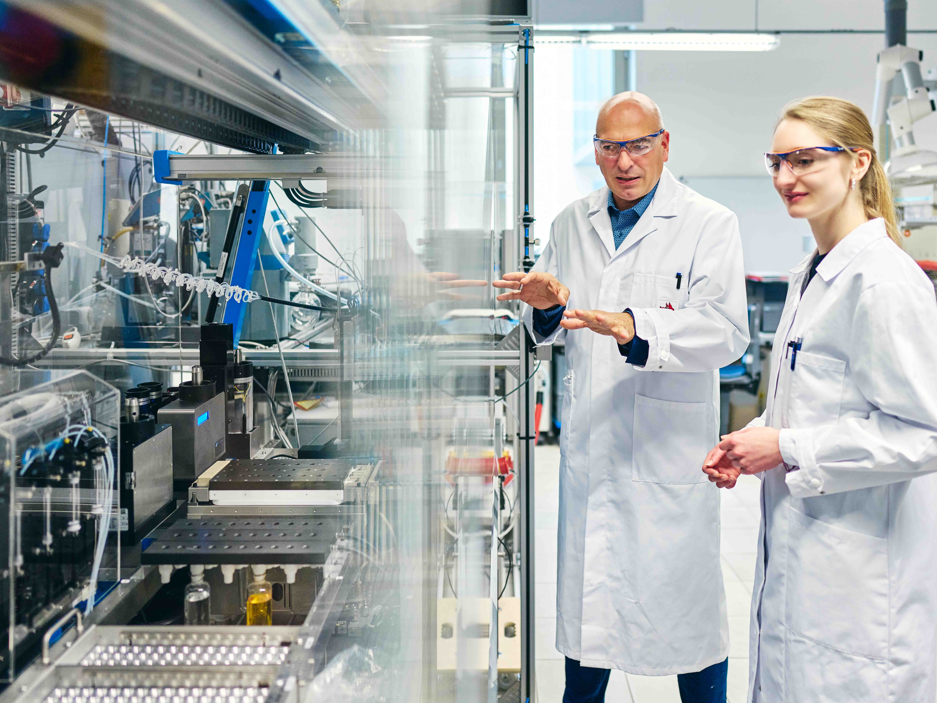 Graduiertenkolleg der Universitäten Jena und Bayreuth Prof. Dr. Ulrich S. Schubert und Dr. Natalie Göppert von der Universität Jena vor einem Syntheseroboter zur automatischen Durchführung von Copolymerisationen.