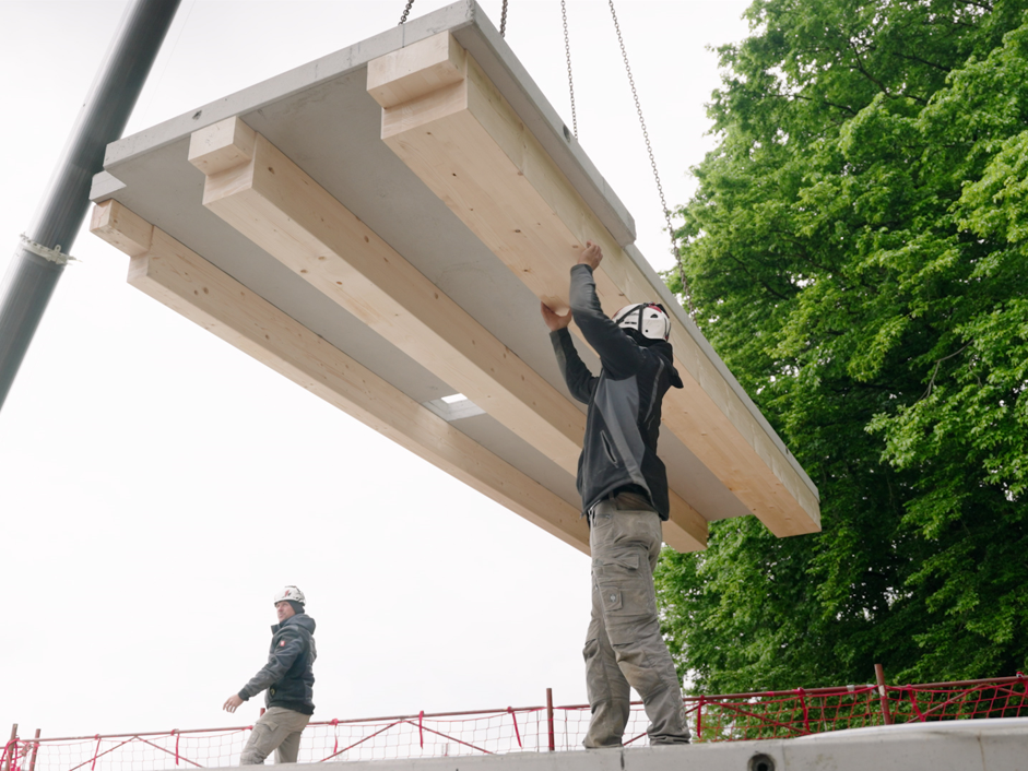 Zimmerer verlegen die Elemente der industriell vorgefertigten und geklebten Holz-Beton-Verbunddecke in einem Wohnhaus in Amstetten Zimmerer verlegen die Elemente der industriell vorgefertigten und geklebten Holz-Beton-Verbunddecke in einem Wohnhaus in Amstetten