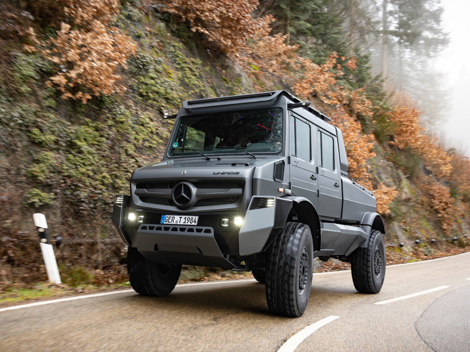 Der Luxus-Unimog auf einer feuchten Gebirgsstraße im Herbst.