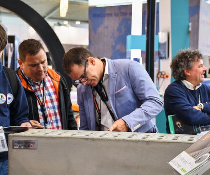Besucher aur einer Messe begutachten Produkte von BG-Graspointner