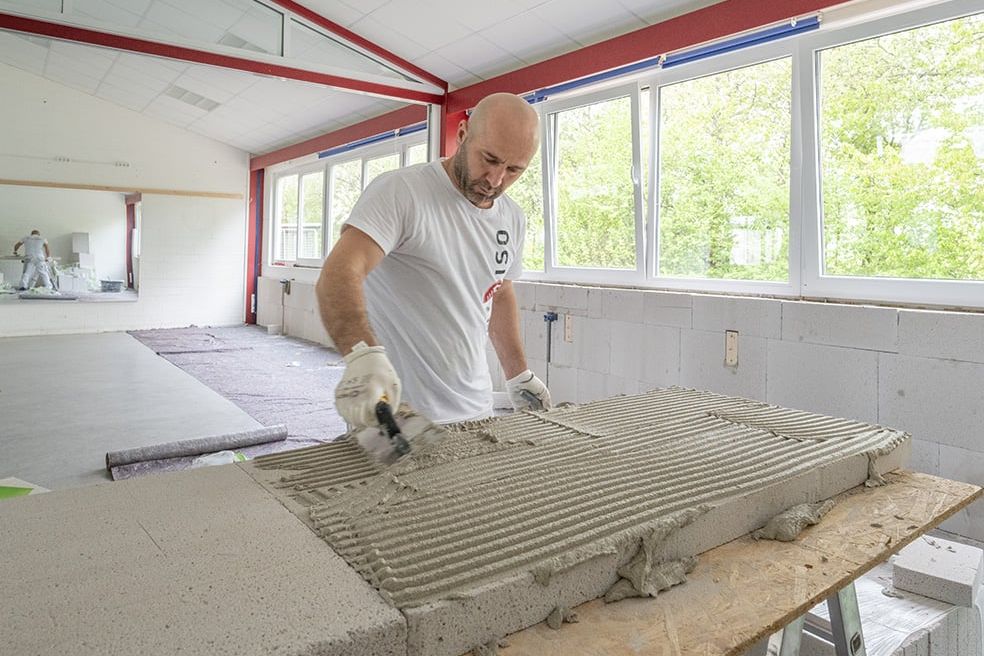 Ein Arbeiter verstreicht Multipor von Xella auf einem Werkstück