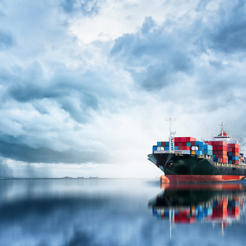ifo-Umfrage: Mehr Industrieunternehmen melden Materialengpässe Containerschiff mit dunkel bewölktem Himmel