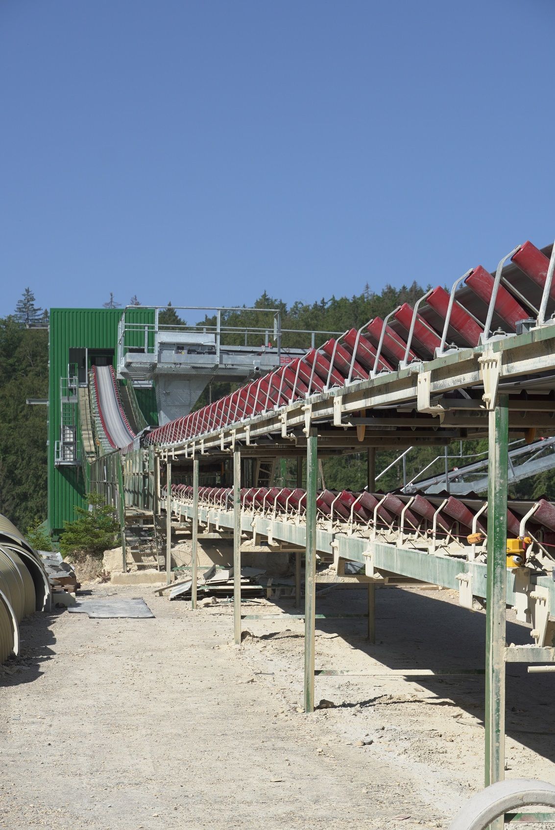 Ein Doppelförderband transportiert den Kalkstein zur Siebanlage über den Puffersilos.