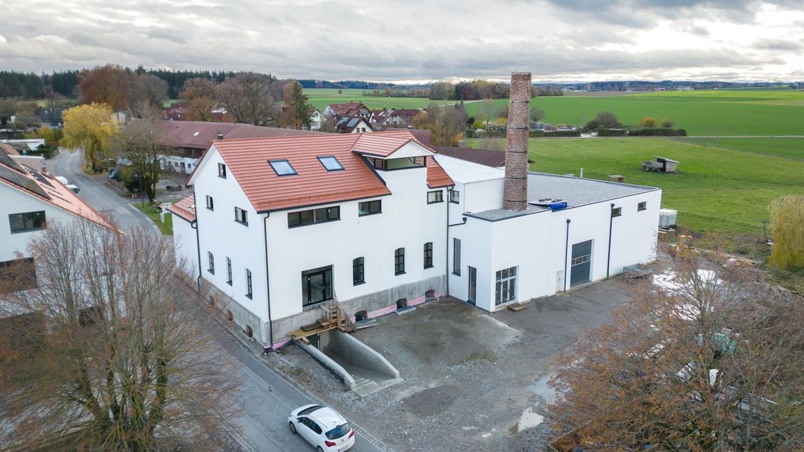 Das Konzept zeigt eine stufenweise Überleitung vom Bestand zum Neubau. Dabei dominiert der Bestand weiterhin in der Architektur. Das Bindeglied schafft einen fließenden Übergang zwischen dem traditionellen Satteldach und dem modernen Flachdach des Hallenneubaus.