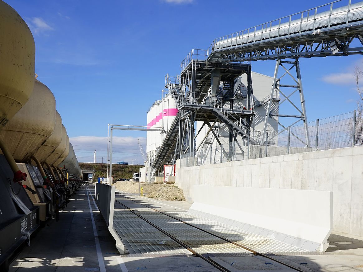 150 m³ fasst der Tiefbunker für die Entladung der Zugschlagstoff-Blockzüge. Vom Übergabeturm aus wird in einer späteren Ausbaustoffe auch die geplante Außendeponie versorgt. 150 m³ fasst der Tiefbunker für die Entladung der Zugschlagstoff-Blockzüge. Vom Übergabeturm aus wird in einer späteren Ausbaustoffe auch die geplante Außendeponie versorgt.