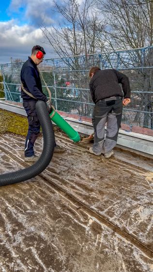 Der auf dem Flachdach verbackene Kies wird mit dem Spatel gelöst und direkt aufgesaugt. Der auf dem Flachdach verbackene Kies wird mit dem Spatel gelöst und direkt aufgesaugt.