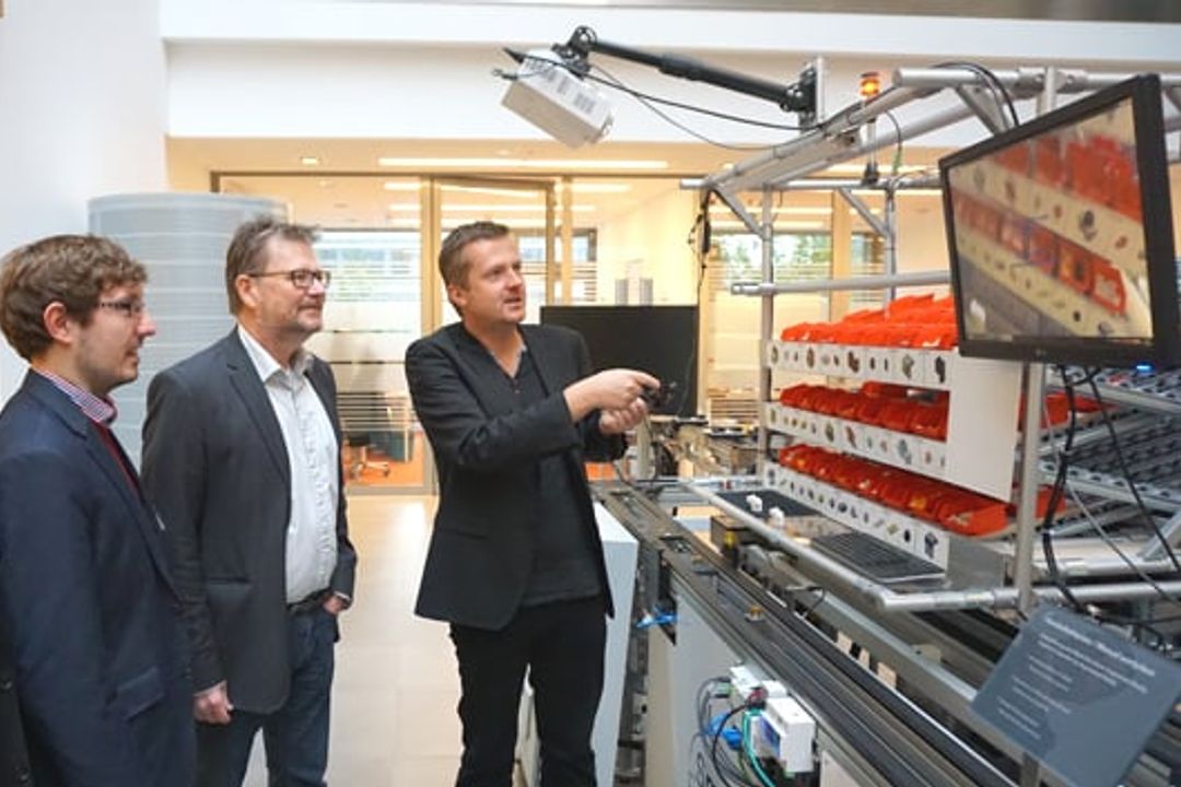 Aksel Jorgensen, Adam Adam Gasiorek, Ulrich Bührer und Oliver Niggemann an der Modellanlage der SmartFactory OWL