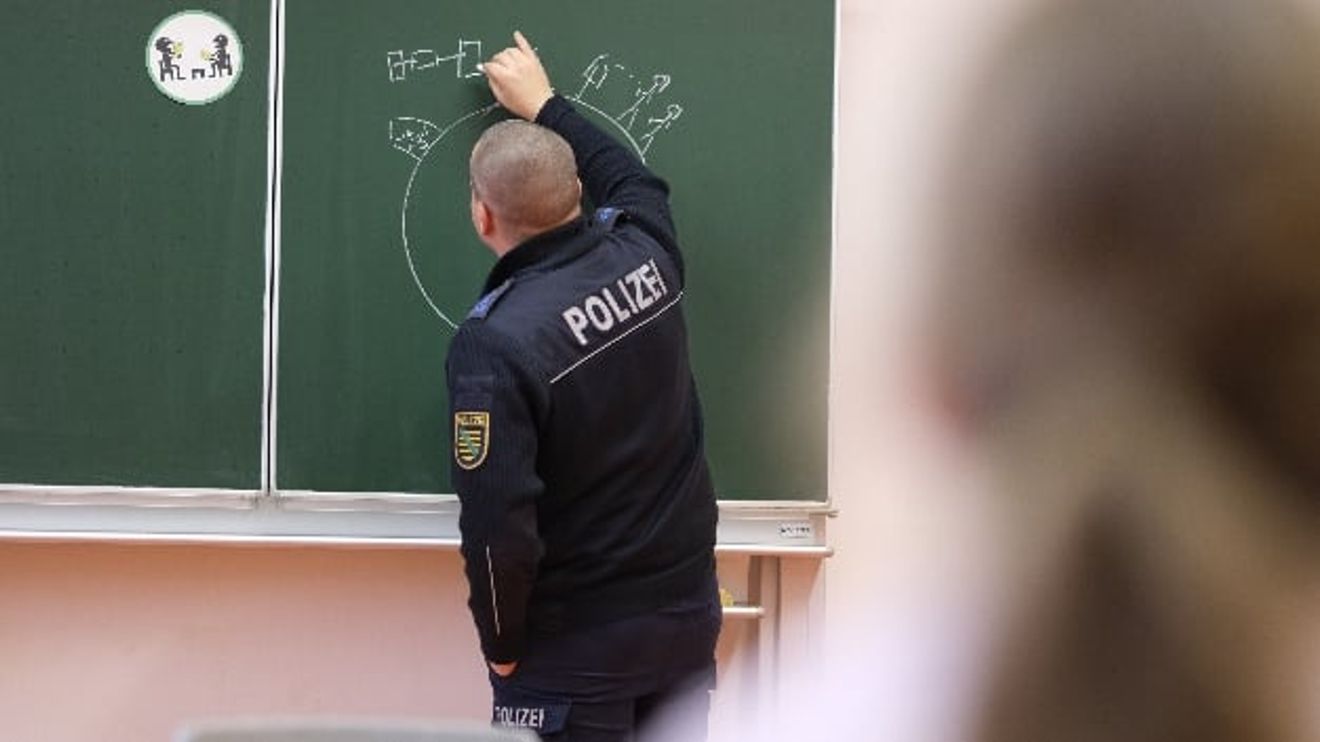 A police officer draws on the blackboard in front of pupils at an elementary school. To mark the international "Safer Internet Day", prevention officers educate children about the dangers of using digital media A police officer draws on the blackboard in front of pupils at an elementary school. To mark the international "Safer Internet Day", prevention officers educate children about the dangers of using digital media