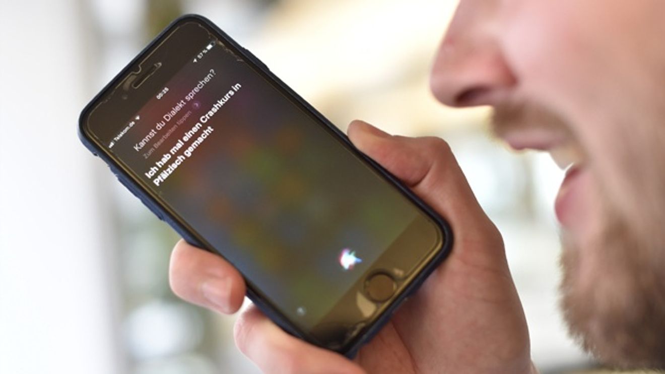 Man uses Siri voice recognition software on his smartphone Man uses Siri voice recognition software on his smartphone
