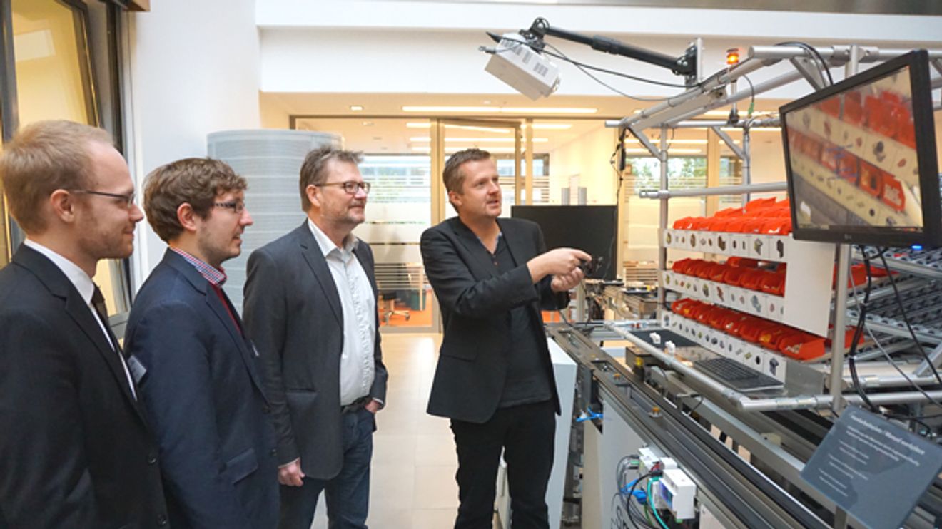 Aksel Jorgensen, Adam Adam Gasiorek, Ulrich Bührer und Oliver Niggemann an der Modellanlage der SmartFactory OWL Aksel Jorgensen, Adam Adam Gasiorek, Ulrich Bührer und Oliver Niggemann an der Modellanlage der SmartFactory OWL