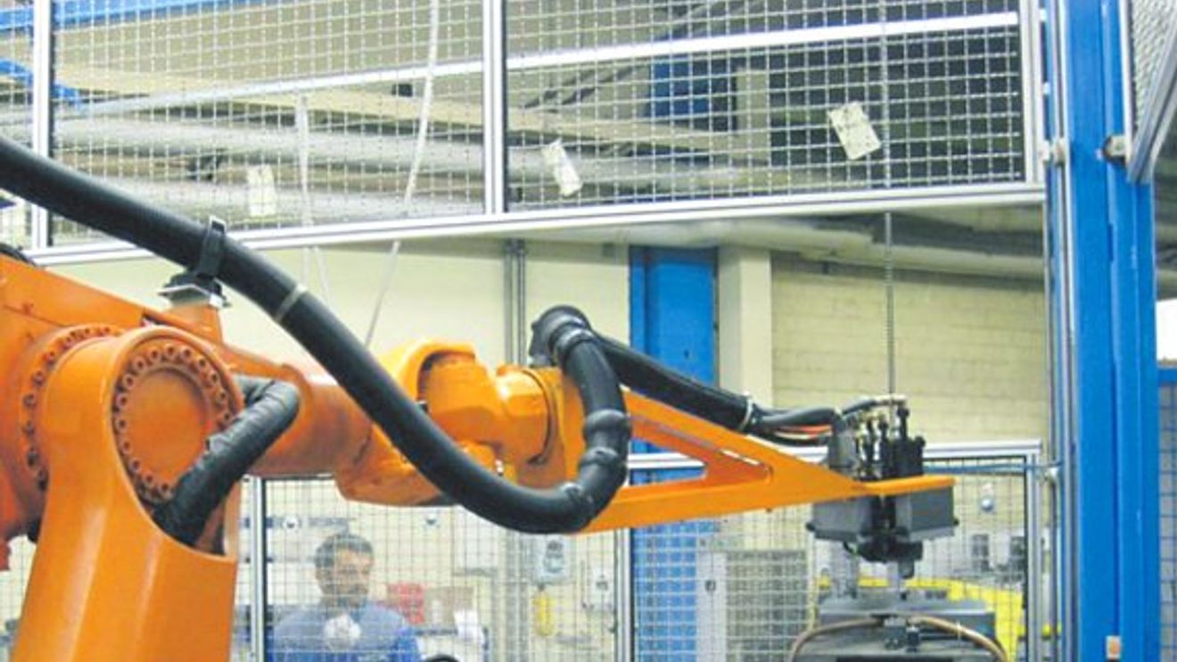 Handling: Werker und Roboter arbeiten Hand in Hand