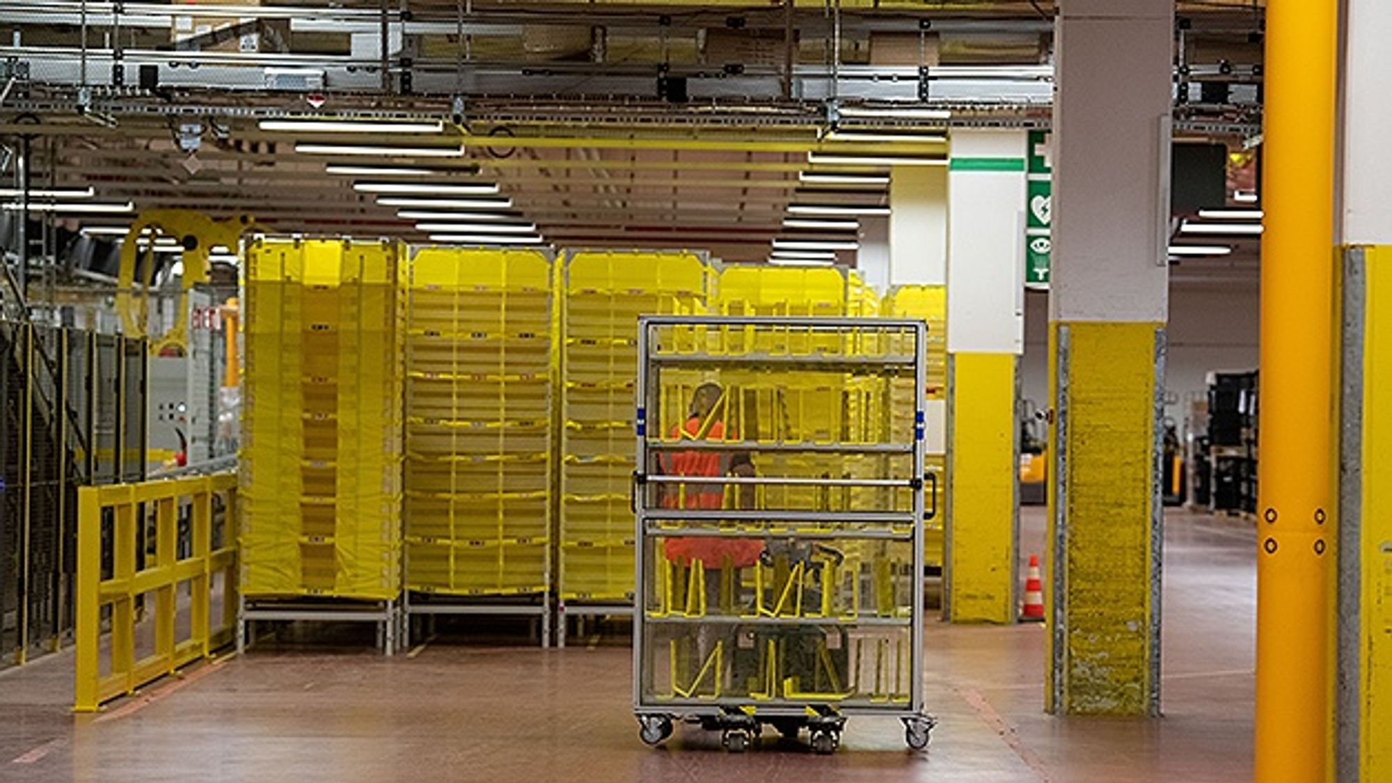 n employee drives an empty pallet truck into a warehouse at Amazon. n employee drives an empty pallet truck into a warehouse at Amazon.