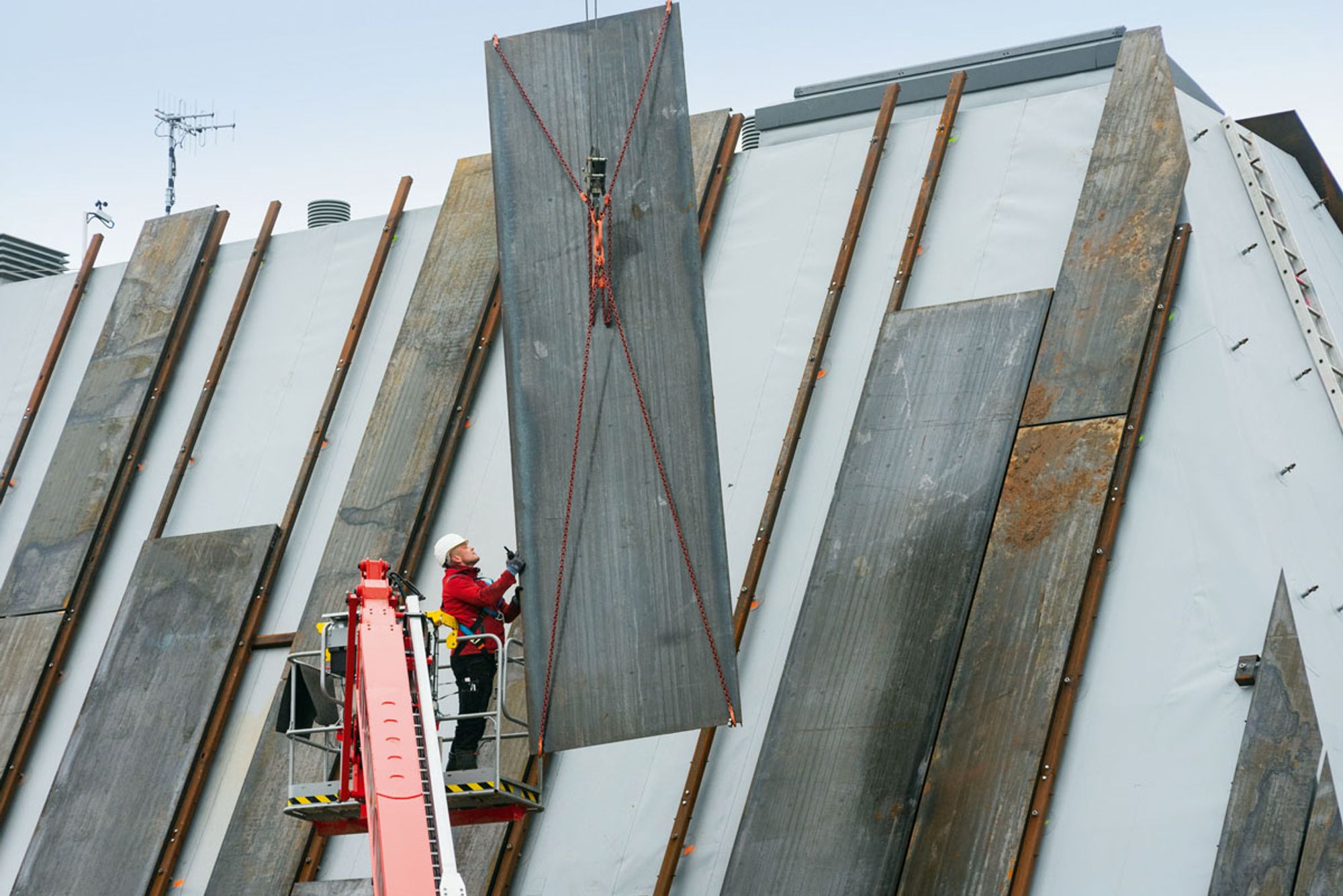 Die Cortenstahlplatten werden in das fertig abgedichtete Dach eingehängt (Foto: Sika)