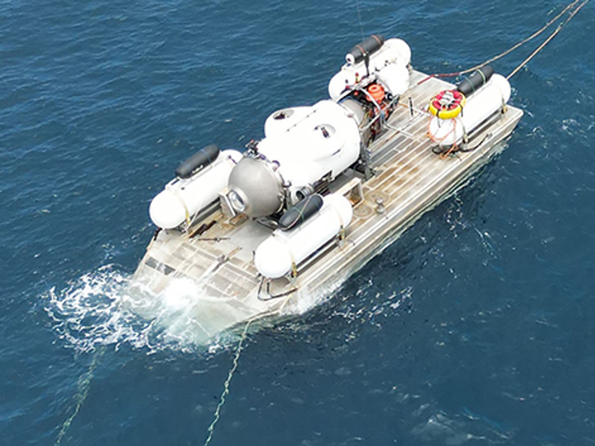 The image shows a drone shot of a submarine on a platform.