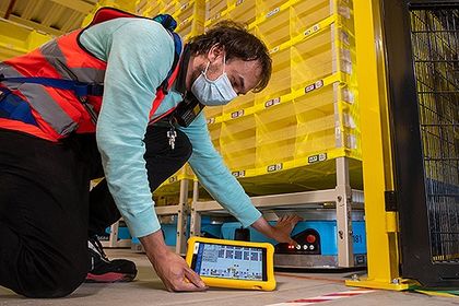 Philipp Weiß kontrolliert bei der Firma Amazon mit einem Tablet Logistikroboter. Philipp Weiß kontrolliert bei der Firma Amazon mit einem Tablet Logistikroboter.