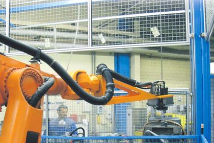 Handling: Werker und Roboter arbeiten Hand in Hand Handling: Werker und Roboter arbeiten Hand in Hand