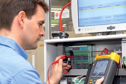 Steuerungstechnik, Mitarbeiter mit Messgerät Steuerungstechnik, Mitarbeiter mit Messgerät