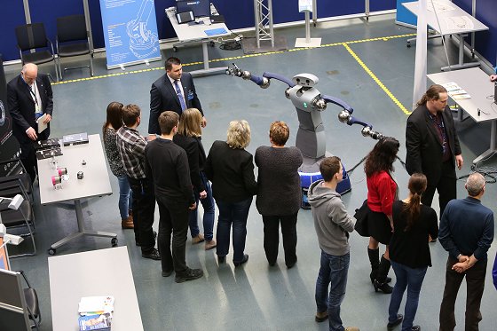 Menschen und Roboter in der Ausstellung